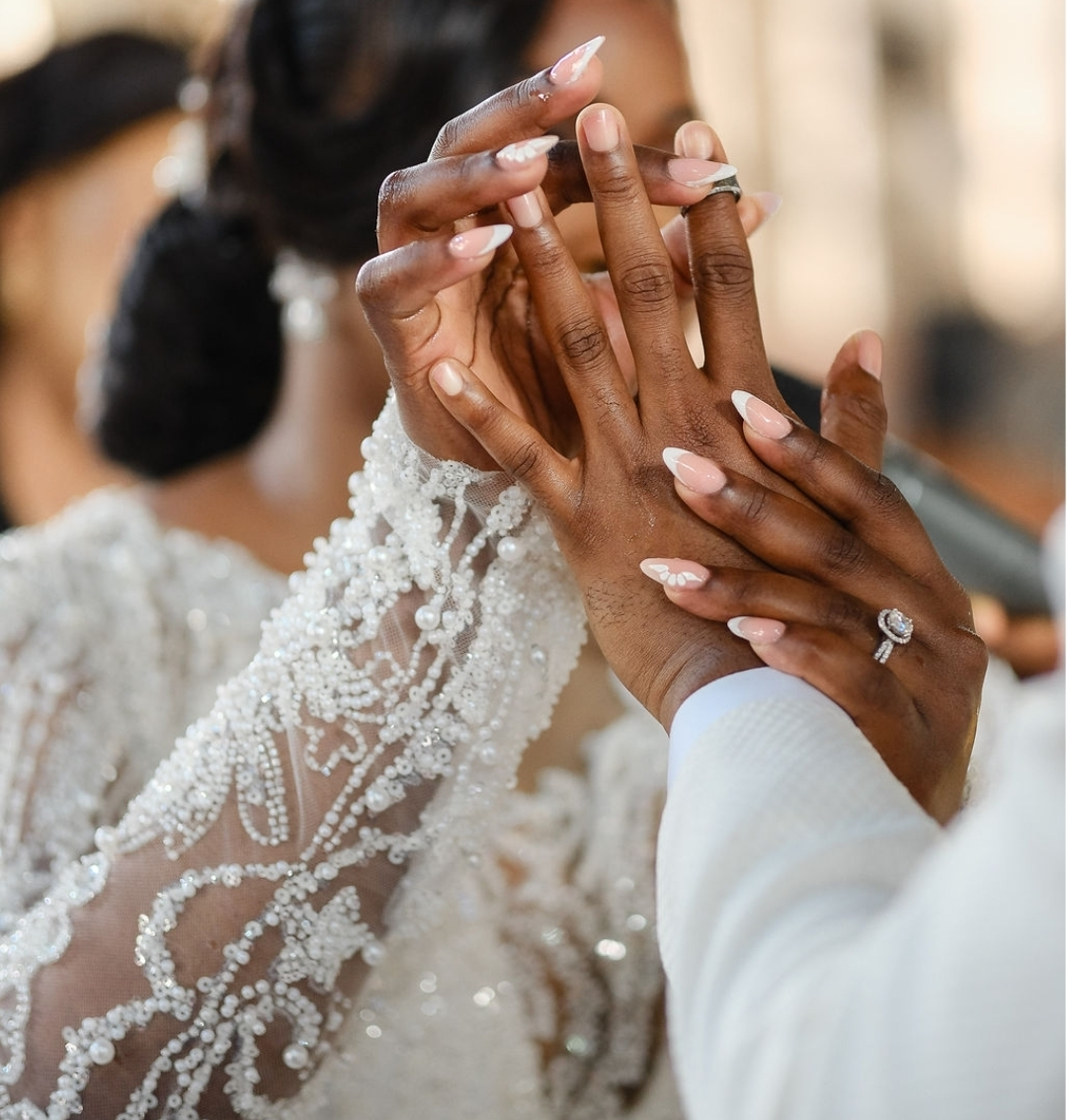 Bride placing a wedding ring on her partner's finger during a ceremony